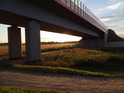 Slunce a cesta pod mostem přes Odru u města Brzeg Dolny.