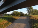 Cesta po pravobřežní hrázi Odry pod silničním mostem, Brzeg Dolny.