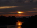 Zapadající Slunce se ztrácí v mracích nad plavebním kanálem Odry kolem města Brzeg.