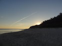 Slunce se začíná objevovat nad špičkami borovic ostrova Wolin u Baltského moře.