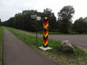 Rozcestník u obce Brieskow-Finkenheerd se sloupkem v německých barvách.